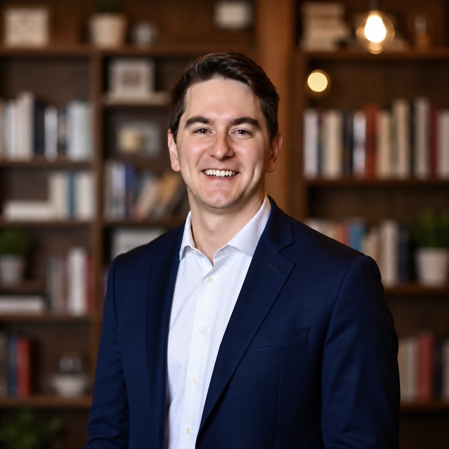 Kyle Fleming, founder of MailedIt, smiling in front of bookshelves
